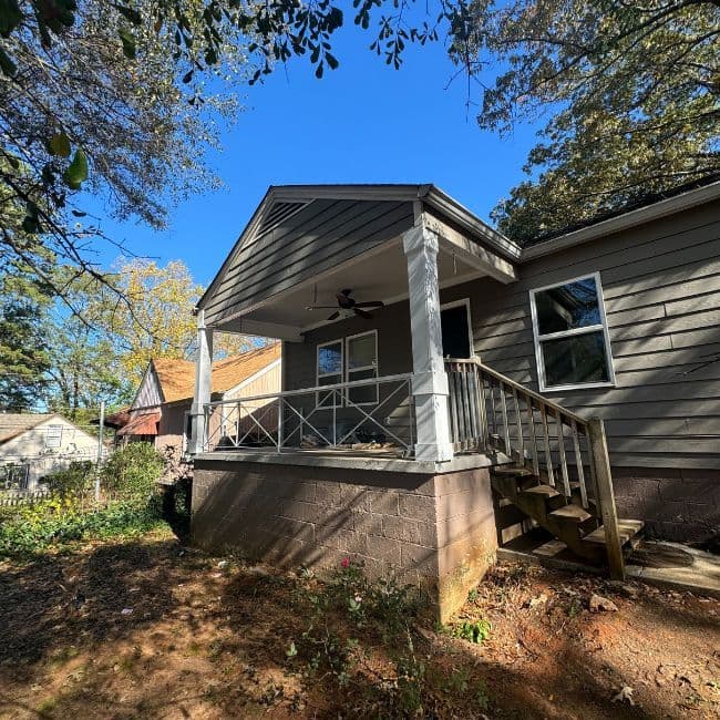 Gray house with a raised side porch and steps.